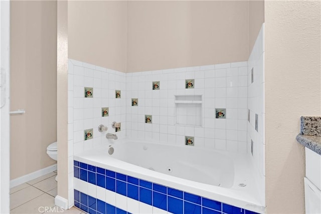 bathroom with tile patterned flooring, baseboards, a whirlpool tub, and toilet