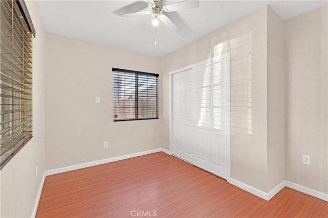 unfurnished bedroom featuring a closet, baseboards, and wood finished floors