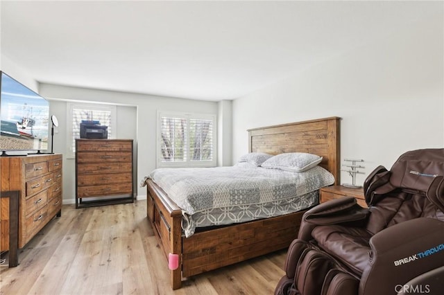 bedroom featuring baseboards and light wood finished floors