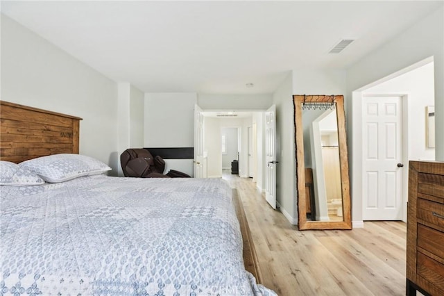 bedroom with visible vents, light wood-type flooring, and baseboards