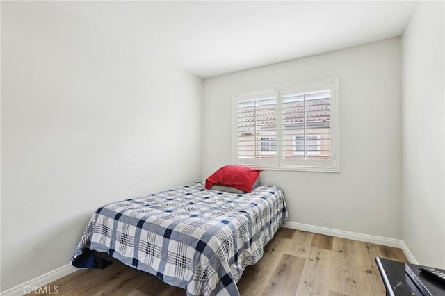 bedroom with baseboards and wood finished floors