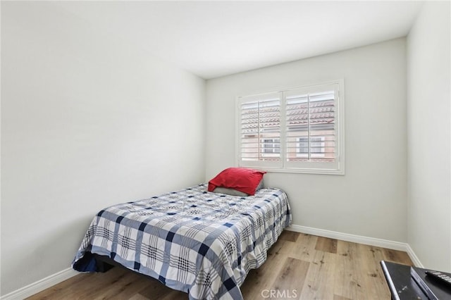 bedroom featuring baseboards and wood finished floors