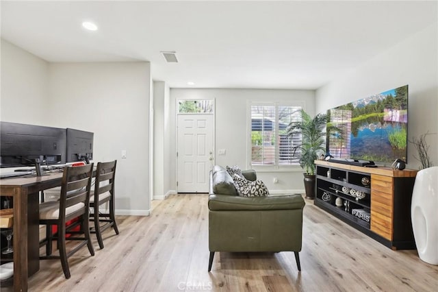 living area with light wood-style flooring, visible vents, baseboards, and recessed lighting