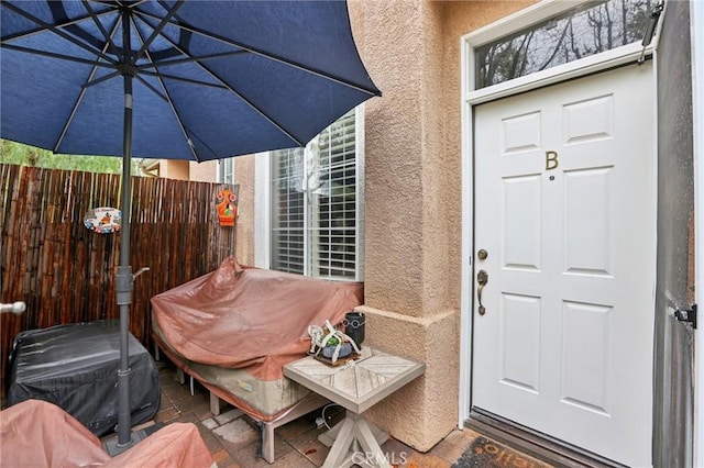 property entrance featuring fence and stucco siding