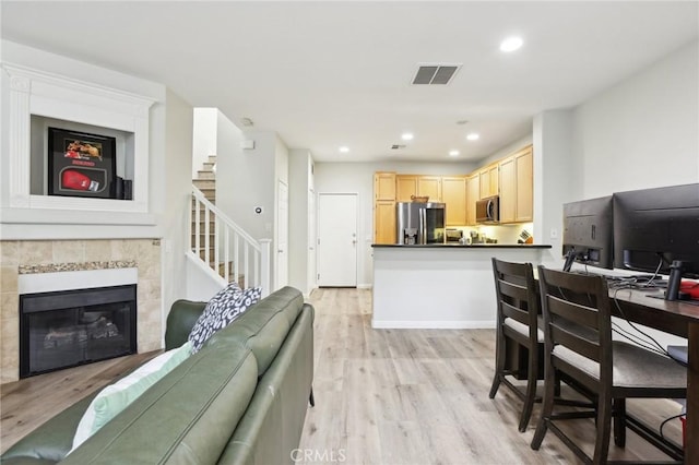 living room featuring visible vents, recessed lighting, light wood-style floors, and stairs