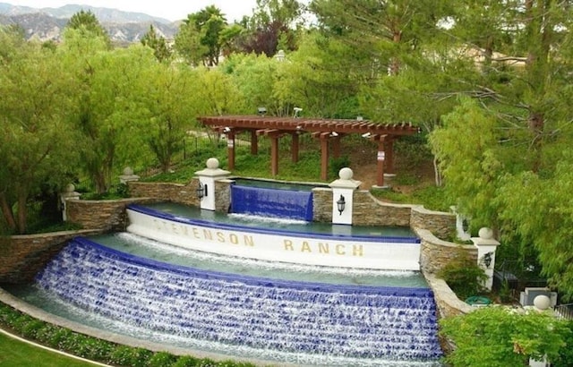 view of home's community with a mountain view and a pergola