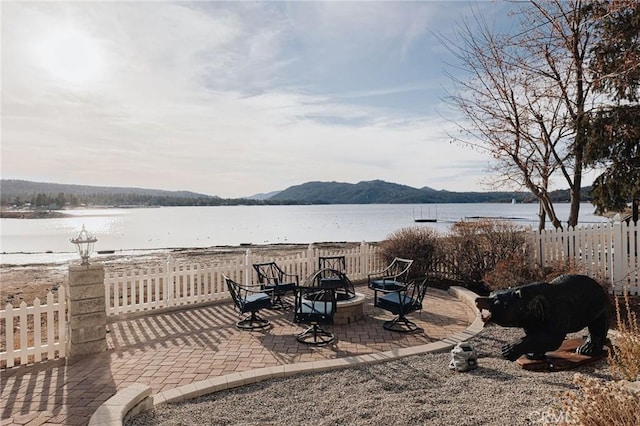 view of yard featuring an outdoor fire pit, a patio area, fence, and a water and mountain view