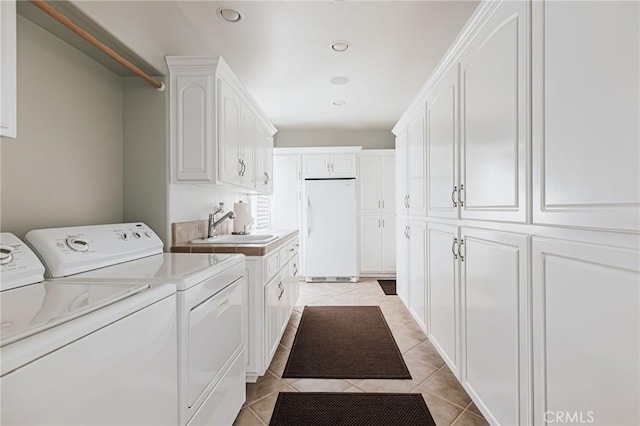 clothes washing area featuring light tile patterned floors, recessed lighting, cabinet space, a sink, and separate washer and dryer