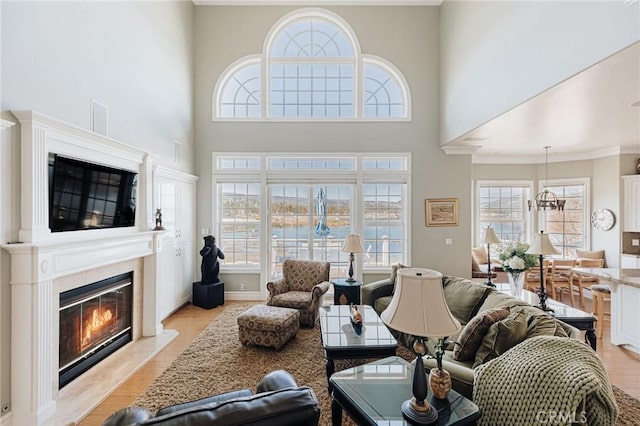 living room featuring a wealth of natural light, light wood-type flooring, a fireplace, and baseboards