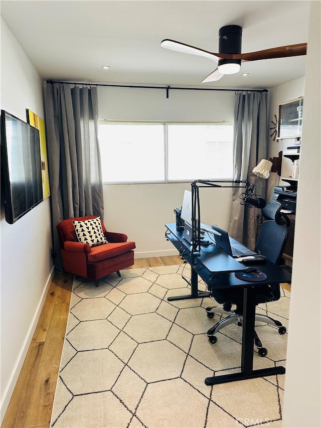 office space featuring ceiling fan, baseboards, and wood finished floors