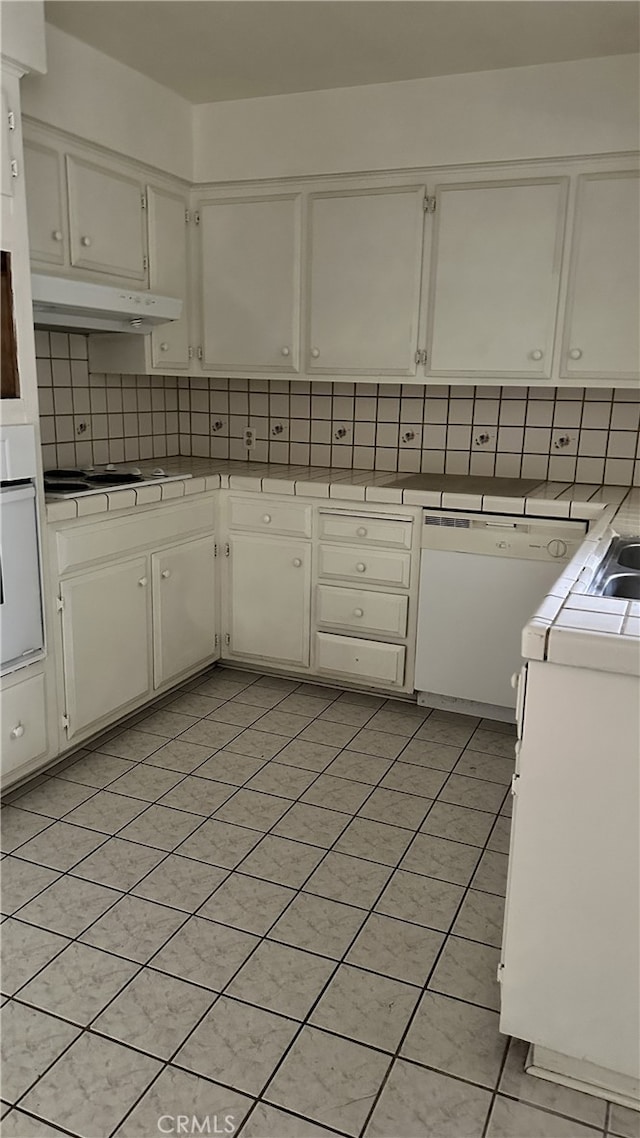 kitchen with white cabinets, white appliances, under cabinet range hood, and decorative backsplash