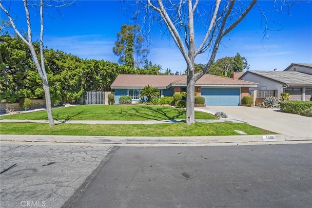 ranch-style house with an attached garage, fence, a tile roof, concrete driveway, and a front lawn