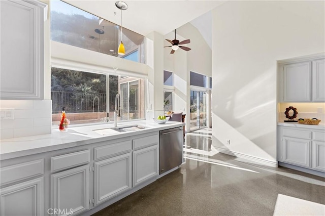 kitchen with pendant lighting, decorative backsplash, a high ceiling, ceiling fan, and dishwasher