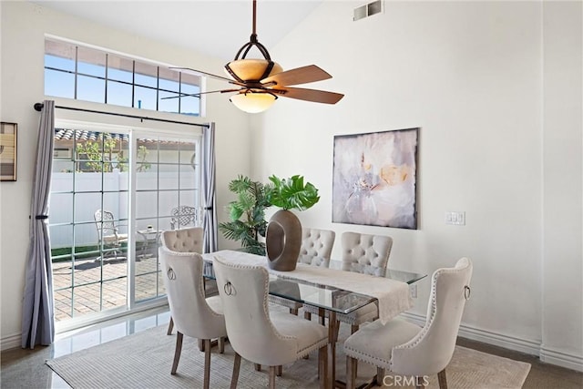 dining space with baseboards, a high ceiling, visible vents, and a ceiling fan