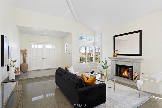 living room featuring high vaulted ceiling, a glass covered fireplace, and baseboards