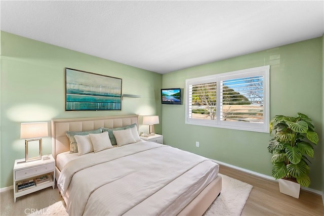 bedroom featuring baseboards and wood finished floors