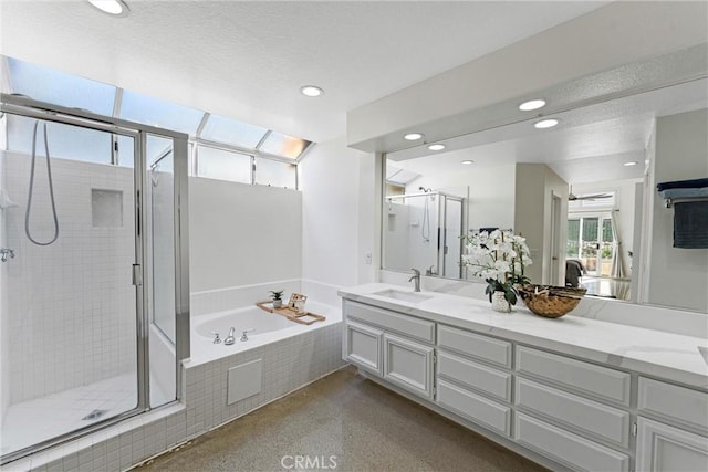 full bath featuring a stall shower, a garden tub, a textured ceiling, vanity, and recessed lighting