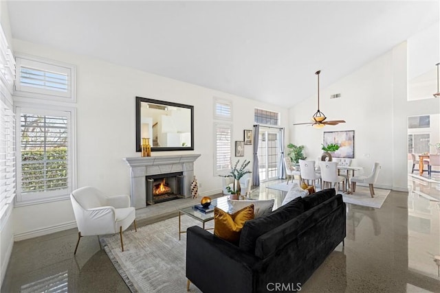 living room featuring a lit fireplace, high vaulted ceiling, baseboards, and speckled floor