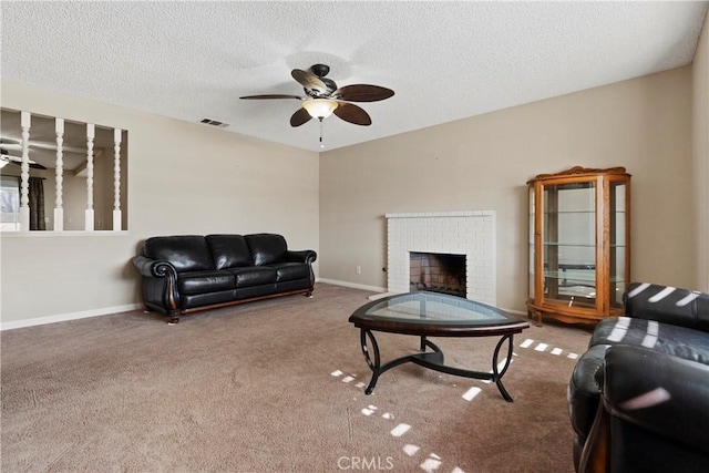 carpeted living room with a textured ceiling, a fireplace, visible vents, baseboards, and a ceiling fan