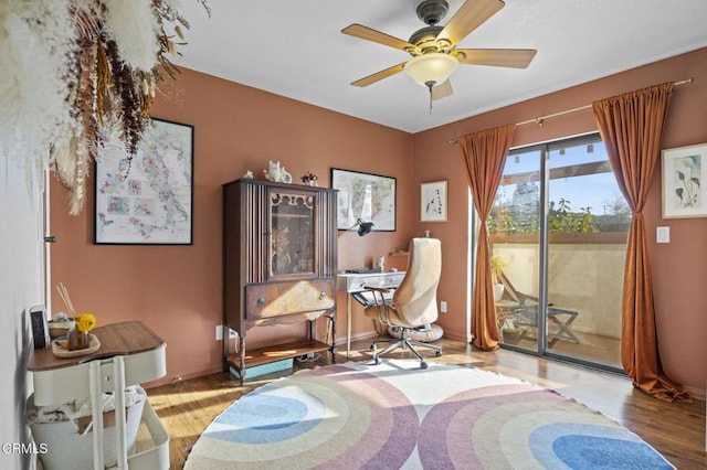 sitting room with a ceiling fan, baseboards, and light wood finished floors