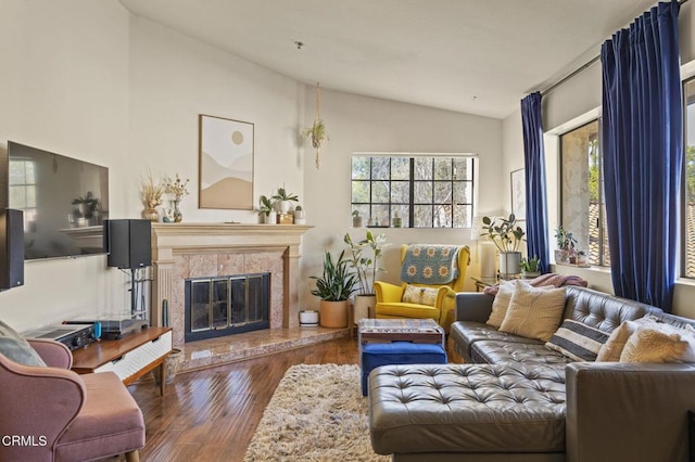 living room with a high end fireplace, lofted ceiling, and dark wood-style floors