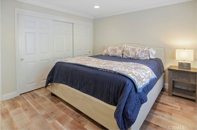 bedroom featuring a closet, crown molding, baseboards, and wood finished floors