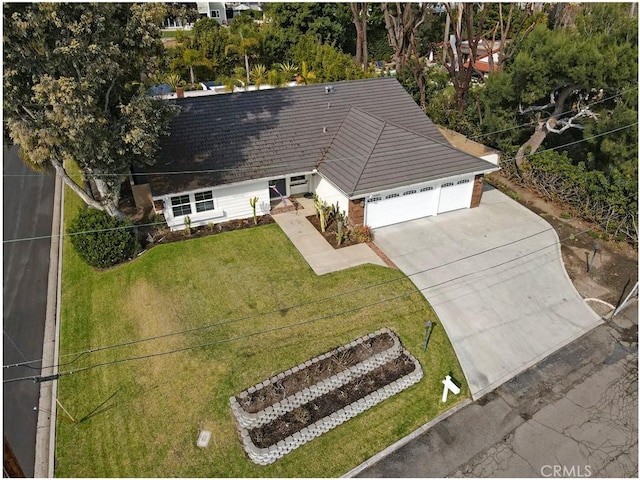 view of front of house with a garage, driveway, a tiled roof, and a front lawn