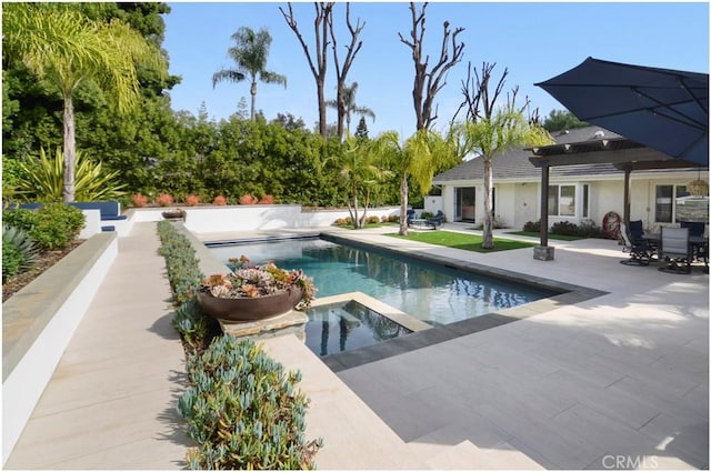 pool with a patio area and an in ground hot tub