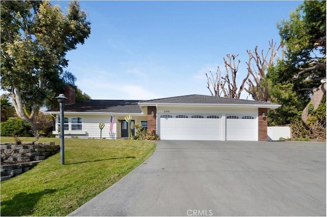 single story home featuring a garage, concrete driveway, and a front yard