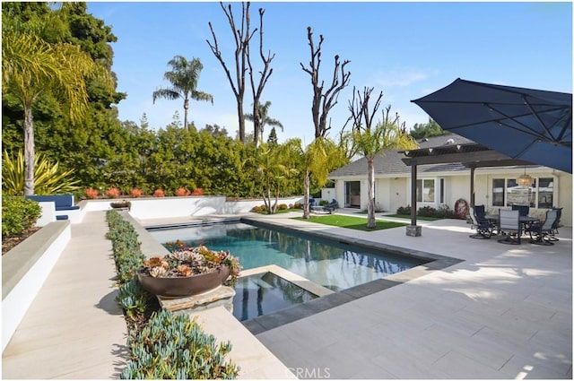 view of pool featuring a patio, a pool with connected hot tub, and a pergola