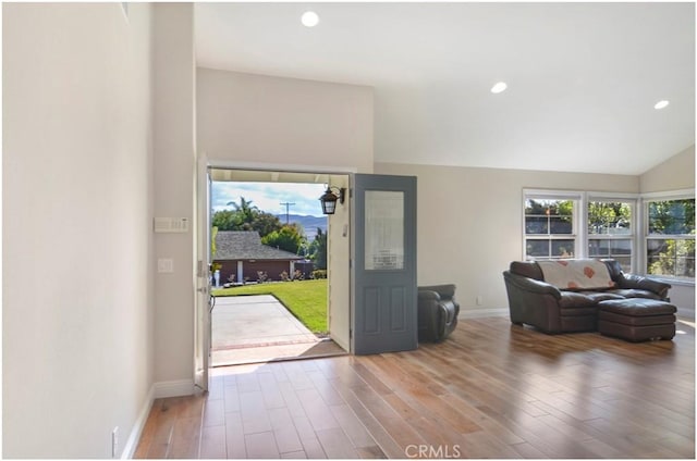 entryway featuring a healthy amount of sunlight, wood finished floors, and lofted ceiling