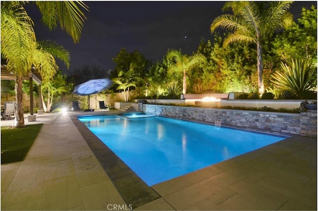 pool at twilight featuring an outdoor pool and a patio