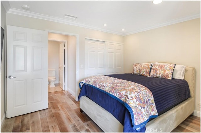 bedroom featuring a closet, visible vents, wood finished floors, and ornamental molding