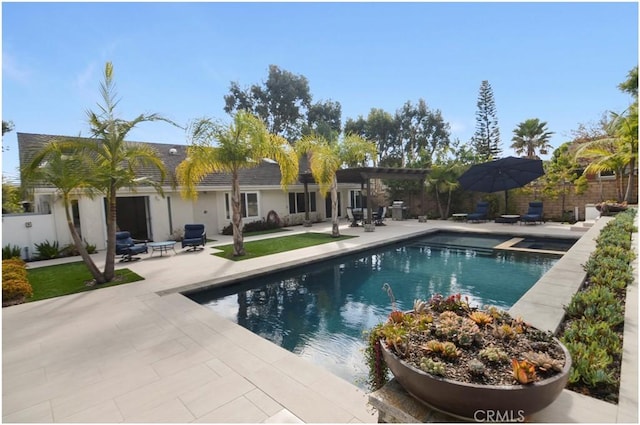 view of pool featuring a patio area, a pool with connected hot tub, and fence