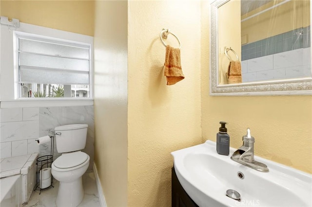 full bath with marble finish floor, a sink, toilet, and a tub