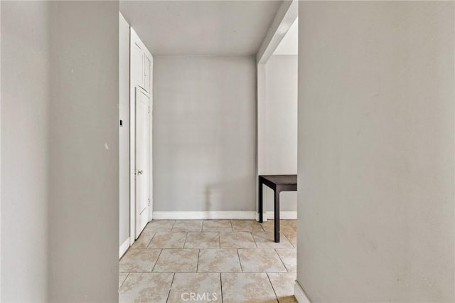 interior space featuring light tile patterned flooring and baseboards