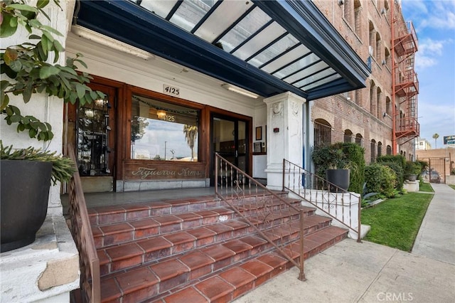 view of exterior entry featuring brick siding