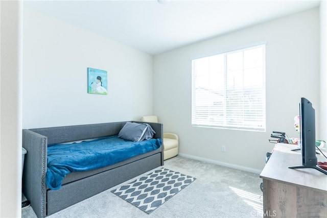 bedroom featuring baseboards and light colored carpet