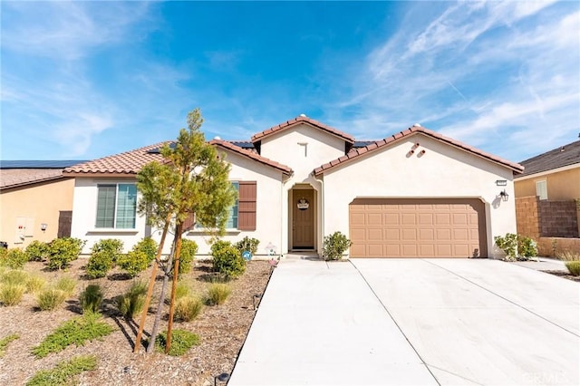 mediterranean / spanish house featuring an attached garage, driveway, a tiled roof, and stucco siding