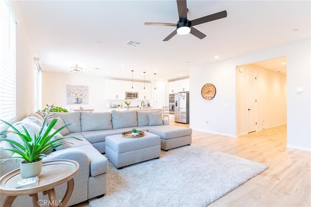 living room featuring visible vents, baseboards, ceiling fan, light wood-style floors, and recessed lighting