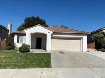 view of front of house featuring a garage, driveway, a front lawn, and fence