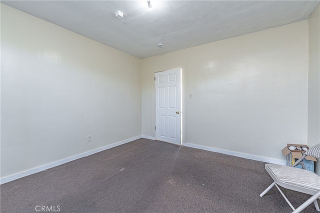 carpeted spare room featuring baseboards