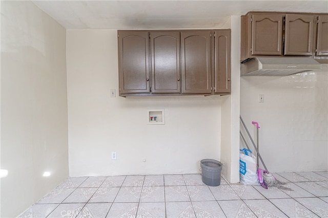 clothes washing area featuring washer hookup, cabinet space, and light tile patterned floors