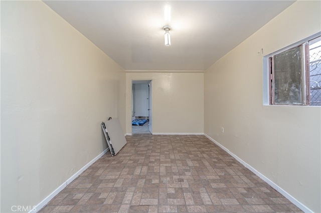 spare room with baseboards