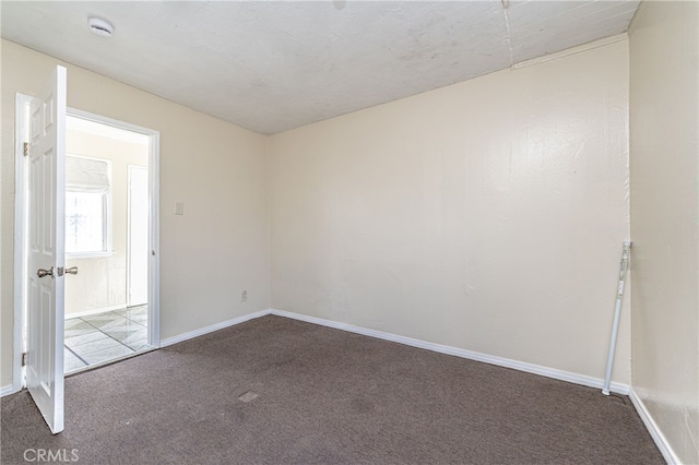 unfurnished room with carpet floors and baseboards