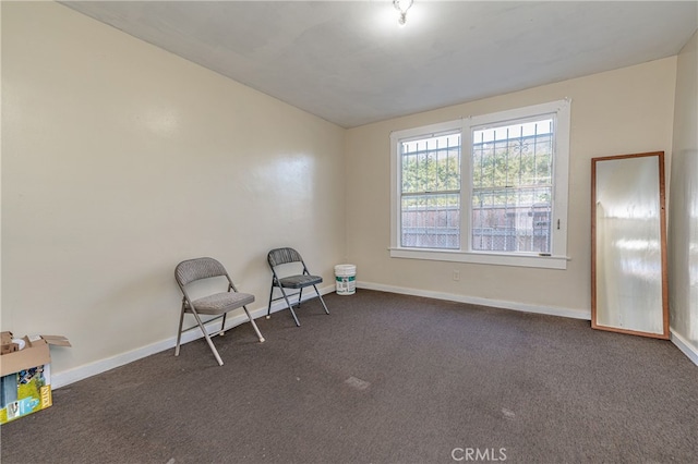 unfurnished room featuring baseboards and dark carpet