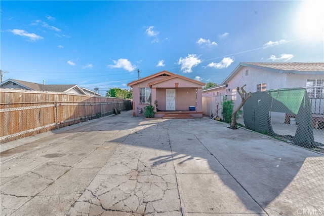 rear view of property featuring a patio area, a fenced backyard, and stucco siding