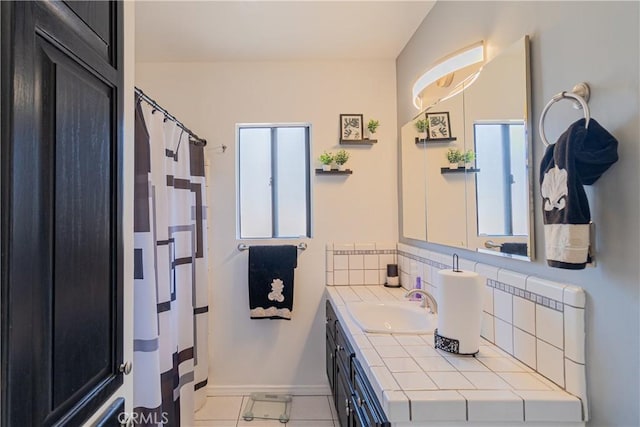 full bath featuring vanity, tile patterned flooring, tasteful backsplash, and a wealth of natural light