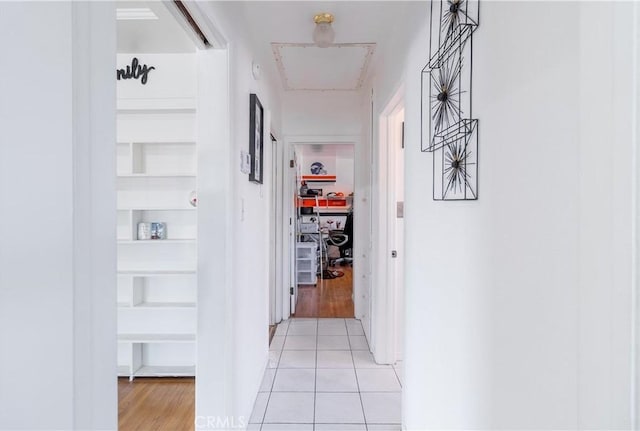 hallway featuring built in shelves and light tile patterned flooring