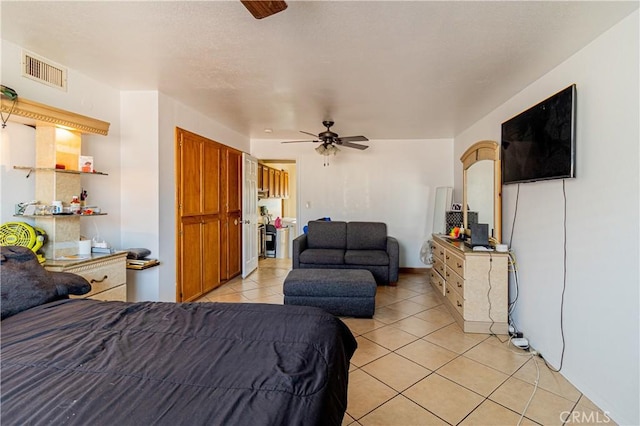 bedroom featuring visible vents, light tile patterned flooring, and a ceiling fan